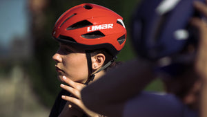 Woman putting on Limar Air Master road cycling helmet