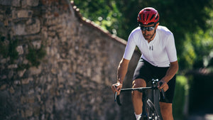 Male cyclist riding uphill wearing Limar Air master bike helmet
